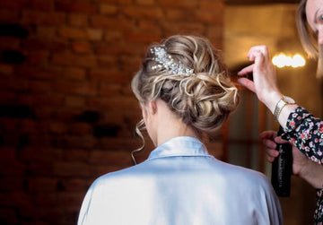 Bridal updo and headpiece being perfected before the ceremony