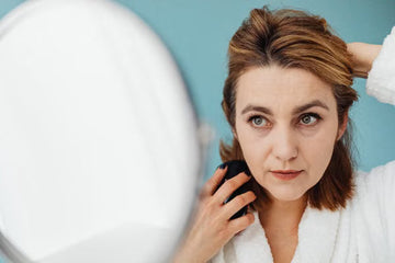 Woman styling her own hair at a mirror at home