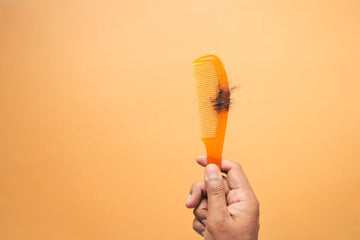 Comb drawn through hair against a plain background