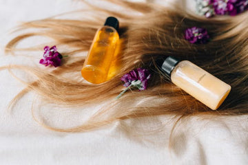 Haircare products laid on a bed of hair and flowers