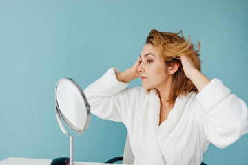 Woman checking her hair at a mirror indoors