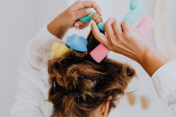 Soft foam curlers being set into hair