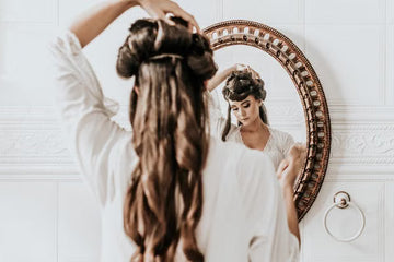 Woman putting her hair up as part of a morning routine