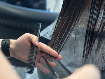 Close-up of a haircut in progress with comb and scissors