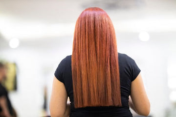 Back view of straight, vibrant red hair in a salon