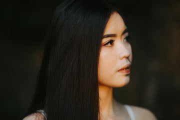 Young woman with long, straight hair in soft light