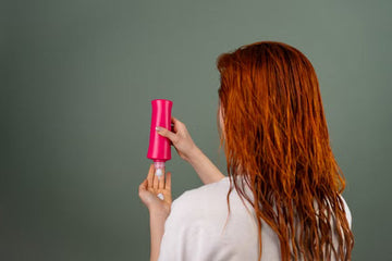 Woman applying conditioner to wet red hair