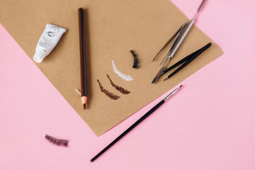 Eyebrow makeup tools arranged on a plain surface