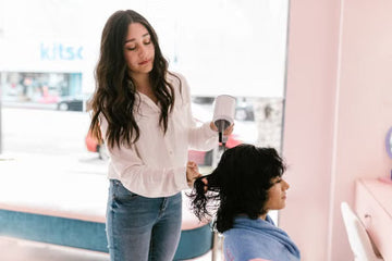 Hairdresser drying a client's thick hair in a salon