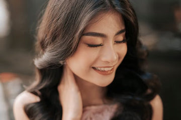 Smiling woman with softly waved hair, eyes closed