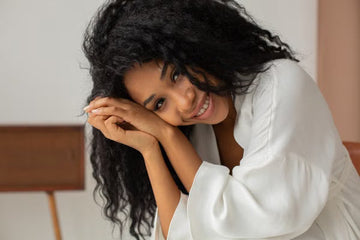 Woman with natural curls smiling in a bathrobe