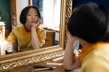 Woman styling her hair at a mirror at home
