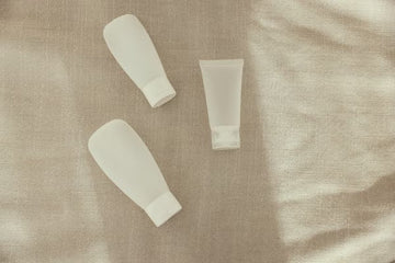 Plain unbranded haircare tubes on linen